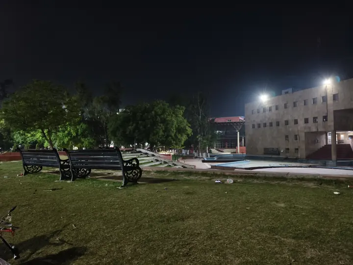 Campus lawn and buildings under floodlights at night