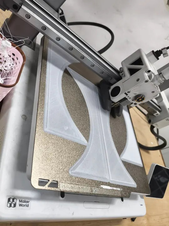 A 3D printer laying down a white part